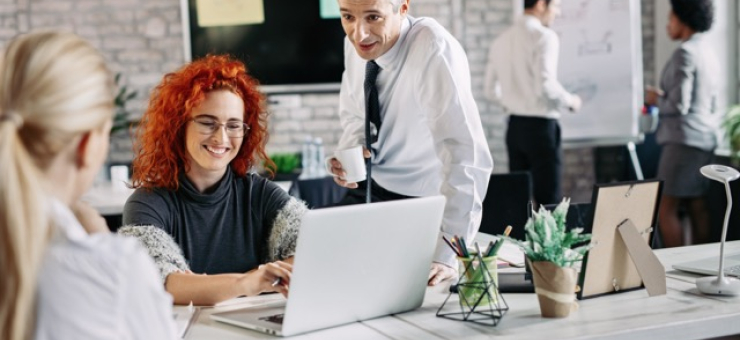 happy-business-people-talking-each-other-while-working-office Medium.jpeg